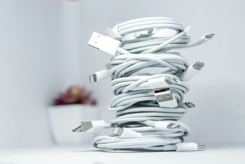 Coiled mobile charging cables on a light surface; illustrative product photograph