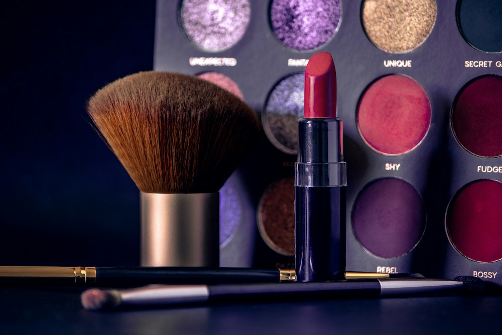 Lipstick, makeup brushes, and an eyeshadow palette; illustrative product photograph