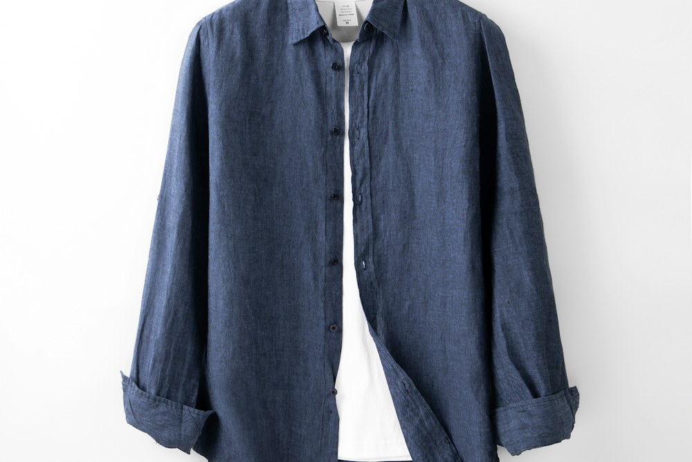 A blue shirt hanging on a white wall; illustrative stock photograph