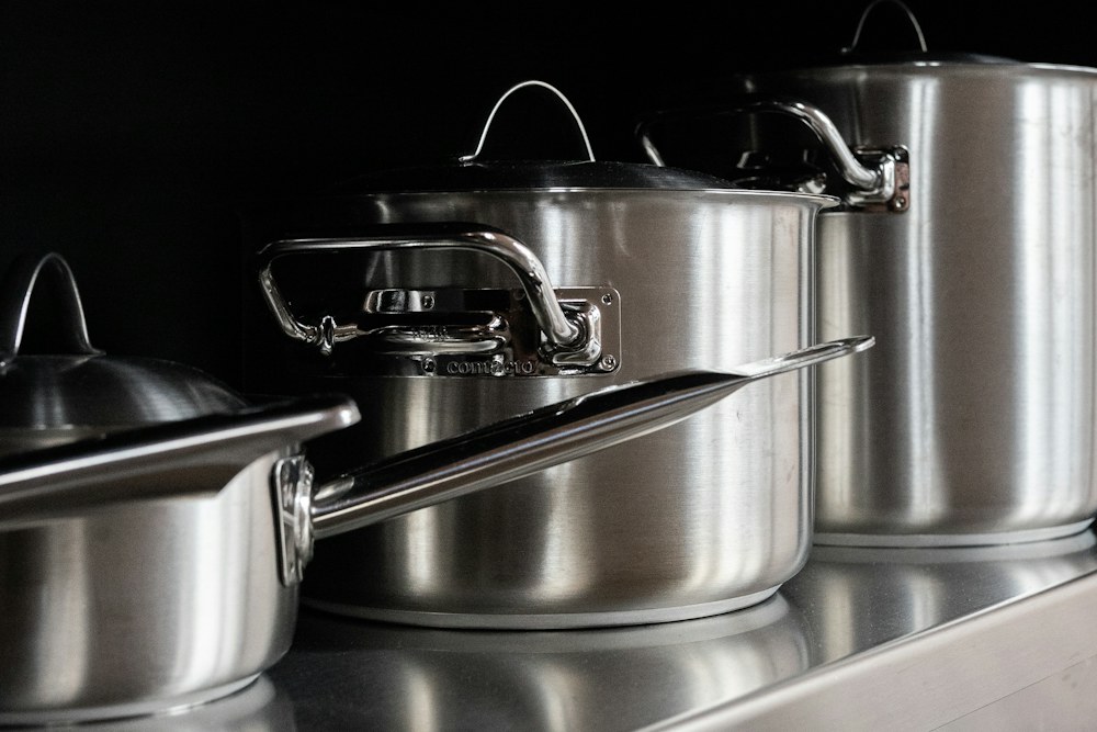 stainless steel cooking pots on stainless steel tray; illustrative stock photograph