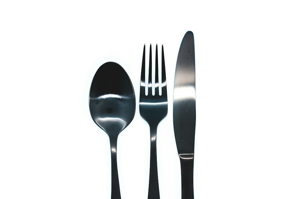 silver spoon and fork on white background; illustrative stock photograph