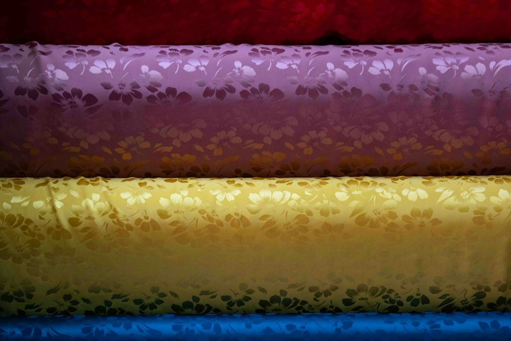 Stacked rolls of colorful patterned fabric; illustrative stock photograph