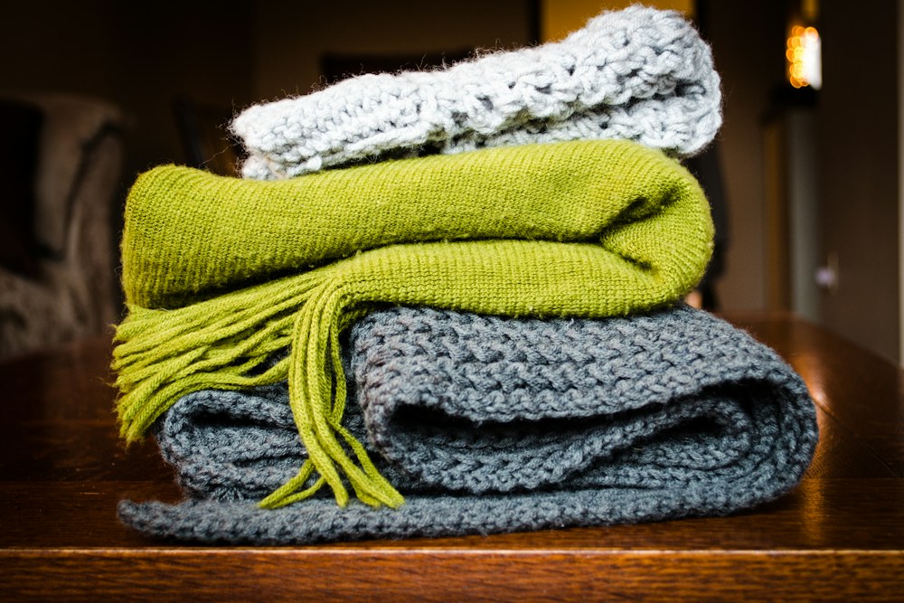 three gray, green, and white scarf on top of table; illustrative stock photograph