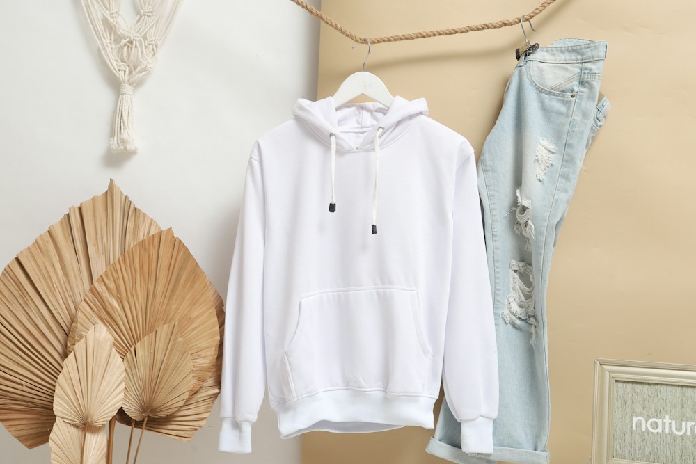 A white hoodie and distressed light blue jeans hanging on a rope; illustrative stock photograph