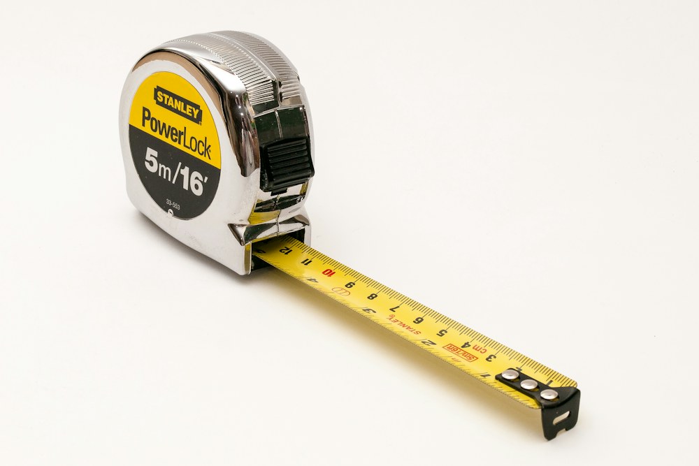 a close up of a tape measure on a white background; illustrative stock photograph