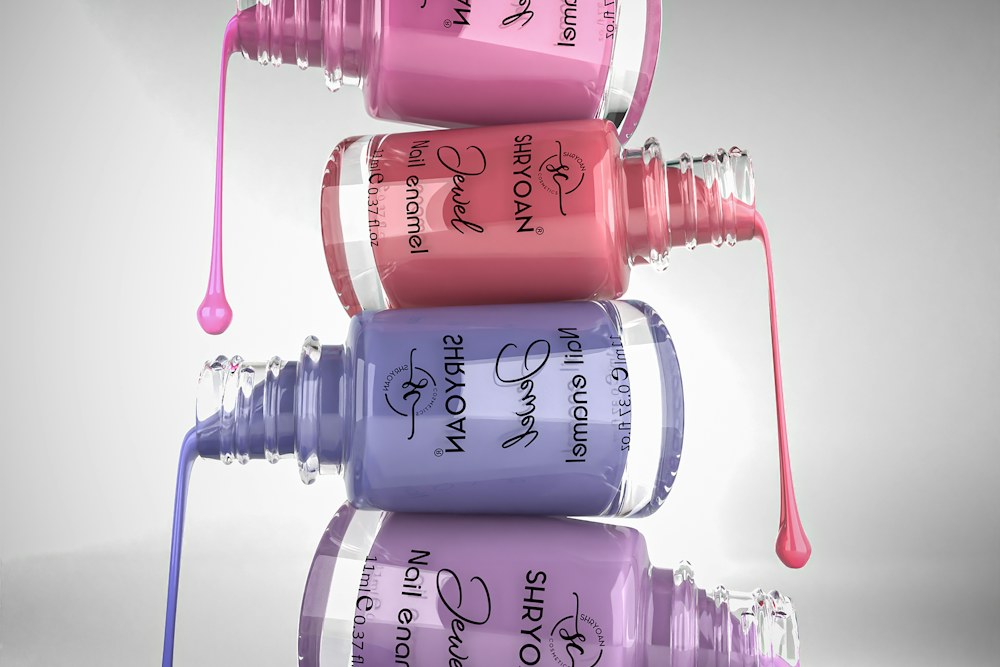 Stack of nail polish bottles with dripping polish; illustrative stock photograph