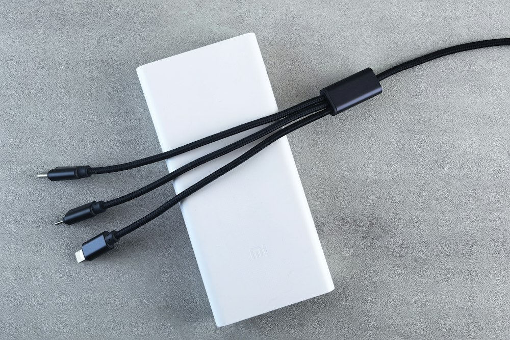 White power bank with three charging cables; illustrative stock photograph