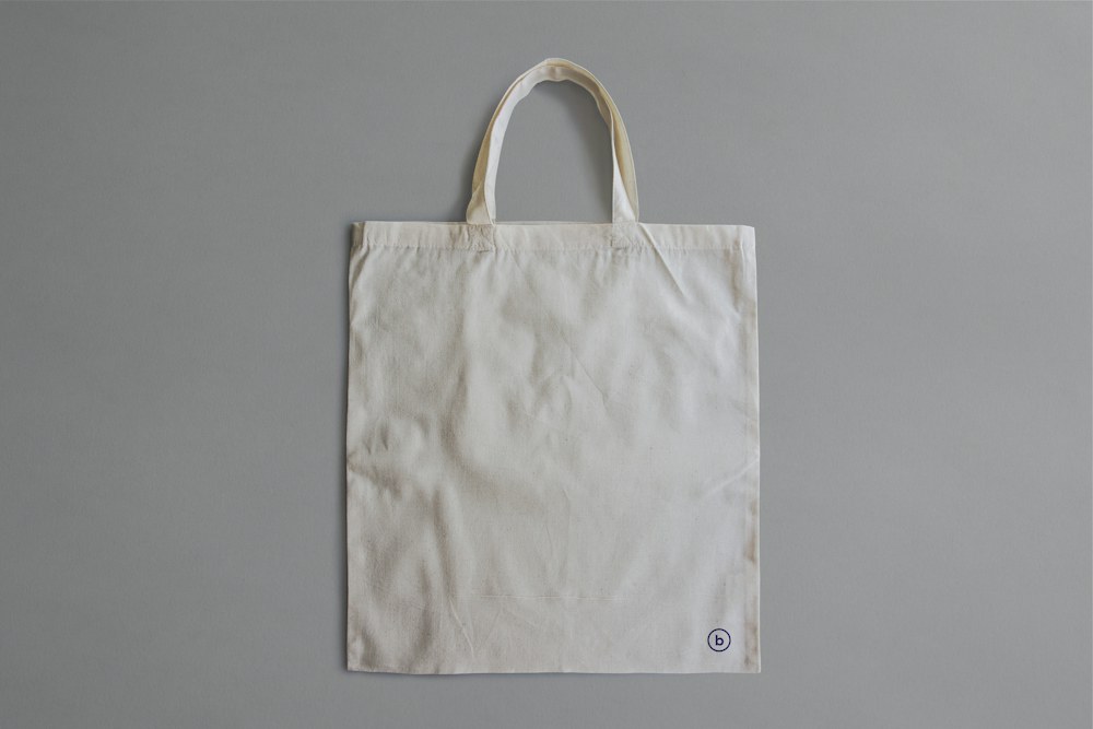 white reusable bag on gray surface; illustrative stock photograph